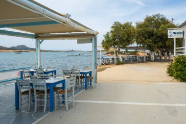 Antiparos, Yunanistan - 28 Eylül 2021: Antiparos adasındaki Yunan sahil restoranında masa ve sandalyeler. Cyclades, Yunanistan