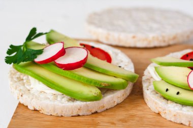 Peynirli sandviç, avokado, domates, turp ve baharatlı. Sağlıklı bir beslenme atıştırması.