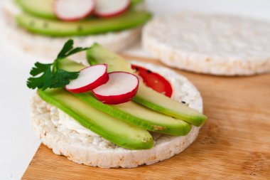 Peynirli sandviç, avokado, domates, turp ve baharatlı. Sağlıklı bir beslenme atıştırması.