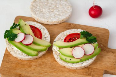 Peynirli sandviç, avokado, domates, turp ve baharatlı. Sağlıklı bir beslenme atıştırması.