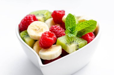 Beyaz arka planda kasede sağlıklı taze meyve salatası.