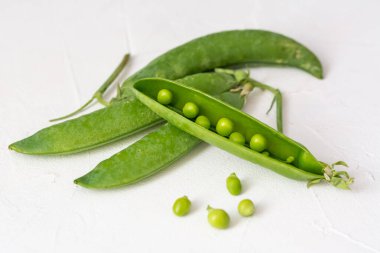 Beyaz arkaplanda taze yeşil bezelyeler