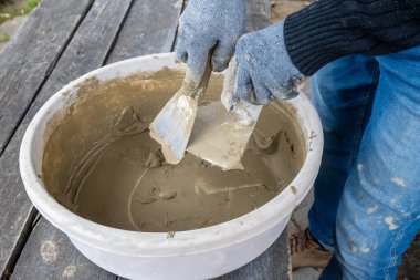 Masonluk işe yarıyor. Mavi eldivenli ve malayla çalışan eller..