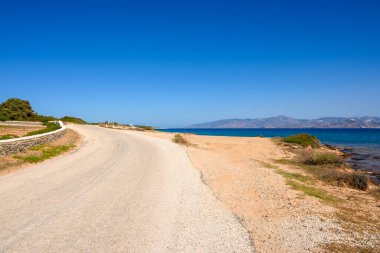 Paros adasının kuzeydoğusundaki sahil şeridindeki yol. Cyclades, Yunanistan