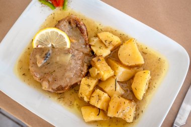 Lokantada patatesle birlikte et suyunda pişirilmiş kuzu eti. Geleneksel Yunan yemeği.