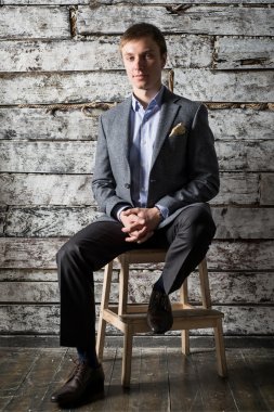 Genç bir adam bir gri takım elbise ve ışık gömlek