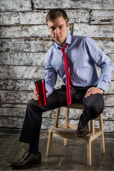 Un joven con una camisa ligera y corbata roja, empleado de oficina posando en el estudio — Foto de Stock