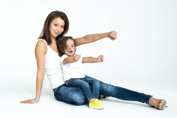 Malá holčička v bílé tričko a džíny, hraje s mámou — Stock fotografie