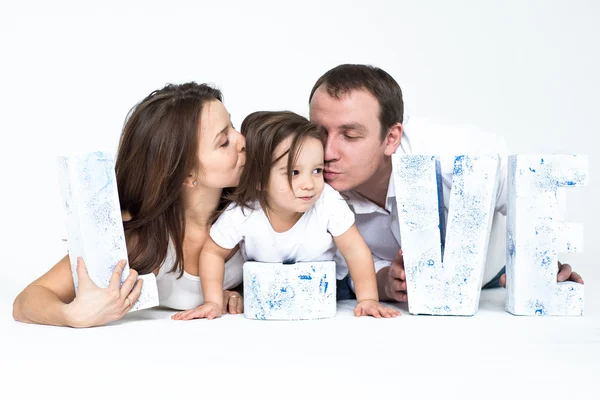 Mladé rodiny: matka, otec a dcera v světlém interiéru — Stock fotografie