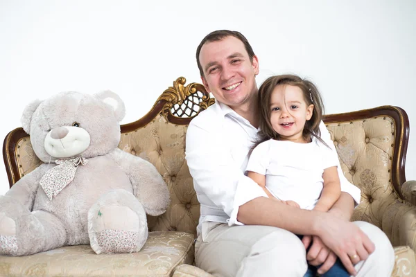 Meisje zittend op de schoot van Papa Stockfoto