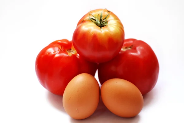 Kilka pomidorów i jaj na stole z widelcem i garnek przyprawy — Zdjęcie stockowe