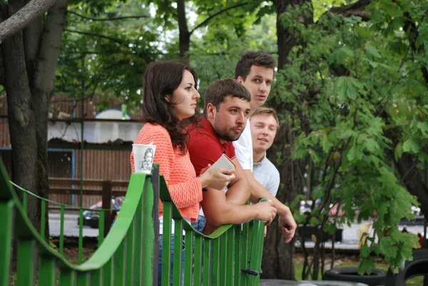 Een groep van jonge mensen kijken naar de races karts — Stockfoto