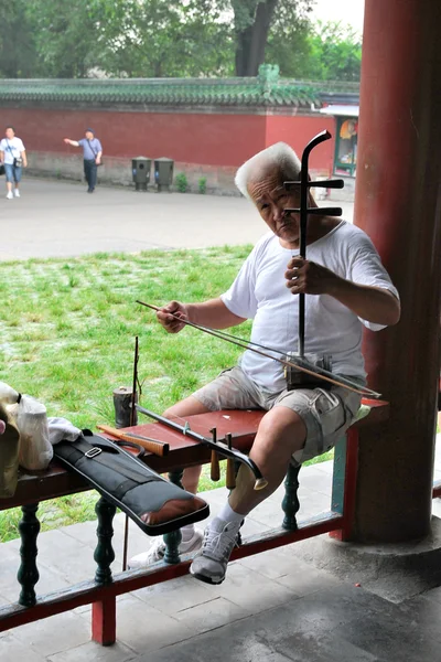 En äldre kinesisk man spelar på en folklig stränginstrument — Stockfoto