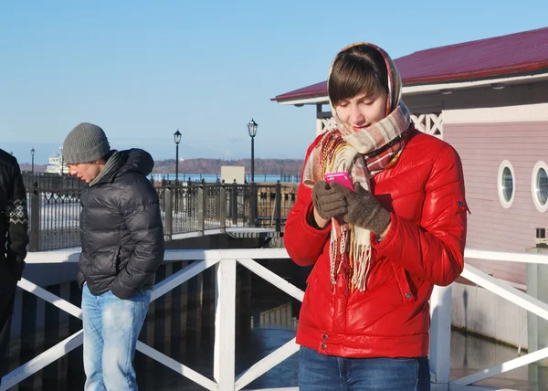 Young girl in a red jacket on the banks of the Volga River in a frosty autumn day — Stock Photo, Image