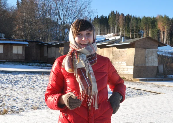 Smiling girl in a red jacket with a mobile phone — Stock Photo, Image