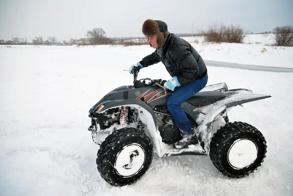 The young man at the time of extreme quad biking in the winter — Stock Photo, Image