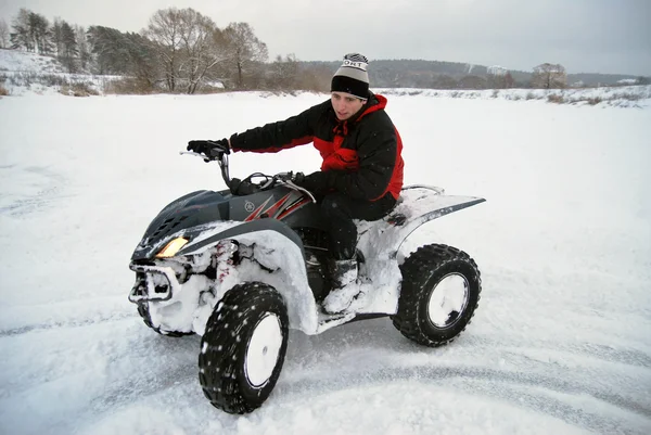 The young man at the time of extreme quad biking in the winter — Stock Photo, Image