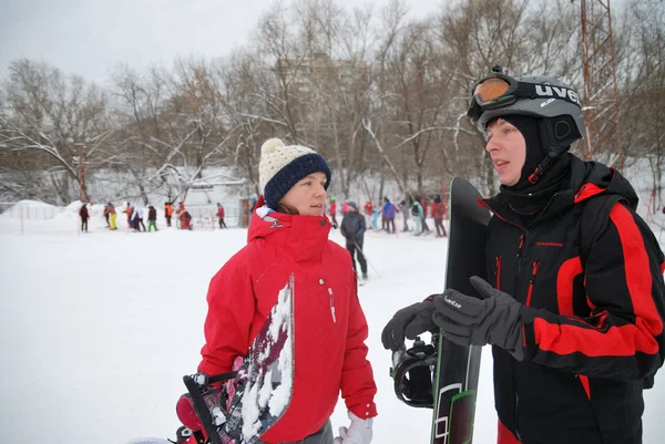 Young snowboarder and instructor descent from the mountain ski resort in Moscow — Stock Photo, Image