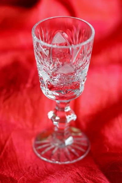 Kristallglas auf rotem Hintergrund — Stockfoto