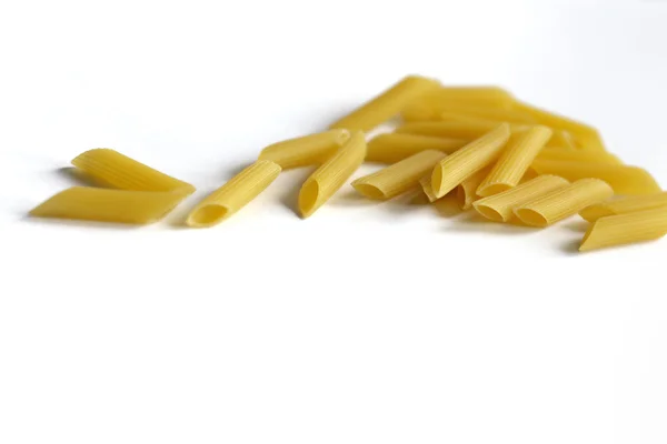 Gul pasta utspridda på ett bord på en vit bakgrund — Stockfoto