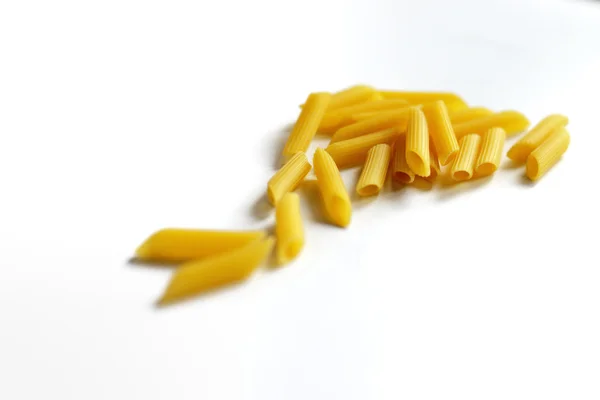 Gul pasta utspridda på ett bord på en vit bakgrund — Stockfoto