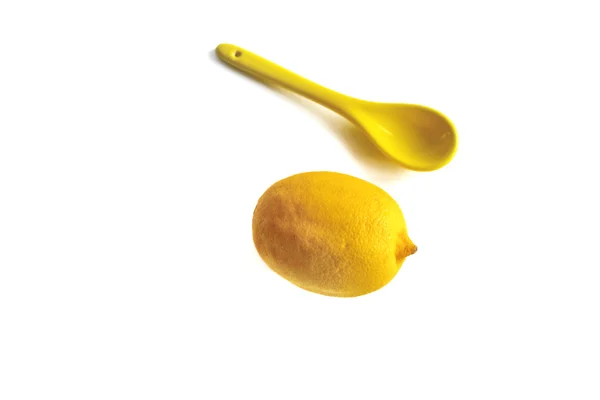 Κίτρινο λεμόνι και κίτρινο κουτάλι σε λευκό φόντο — Φωτογραφία Αρχείου