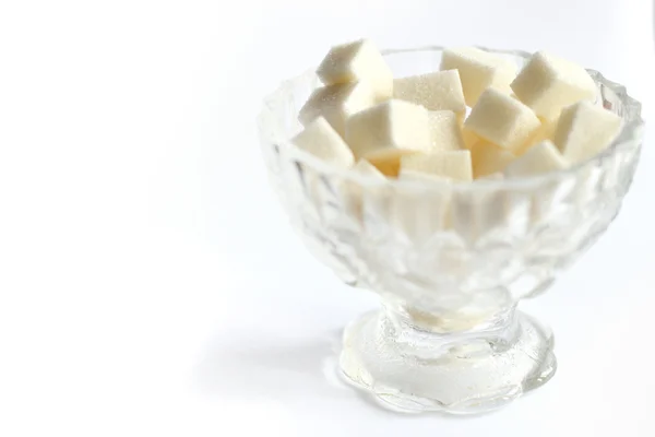 Кусочки сахара в хрустальной сахарной миске на белом фоне — стоковое фото