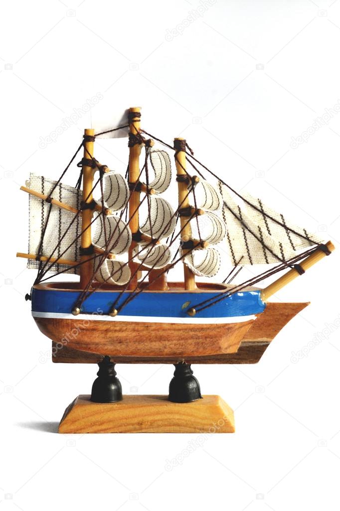 Wooden model ship with sails on a white background