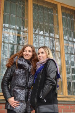 İki kız bir pencere önünde duran