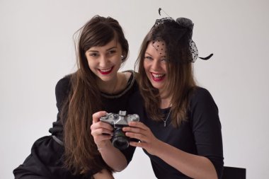 İki genç kız eğleniyor ve bir eski film fotoğraf Zenit makinesi arıyorum