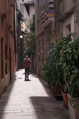 Sirmione Garda Gölü üzerinde dar bir sokakta genç adam