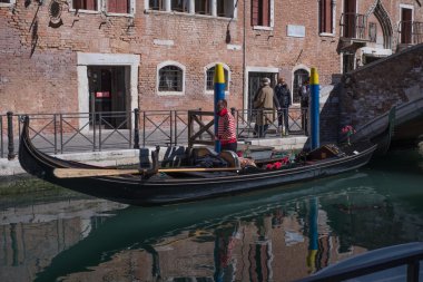 Gondolcu Venedik ve sakin kanallardan biri üzerinde yelken açmaya hazırlanıyor