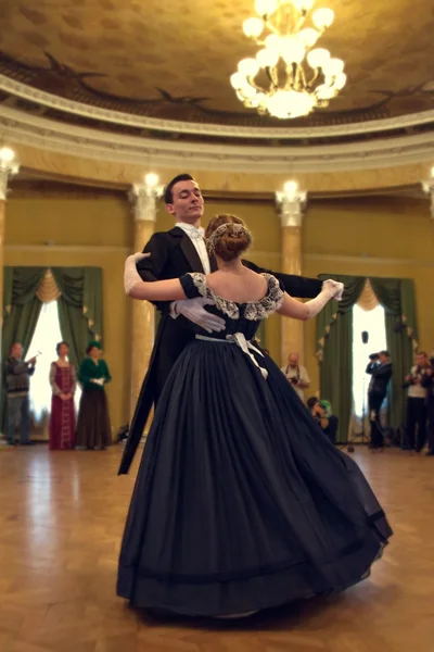 Pareja en vestido histórico bailando un vals en el salón de baile — Foto de Stock