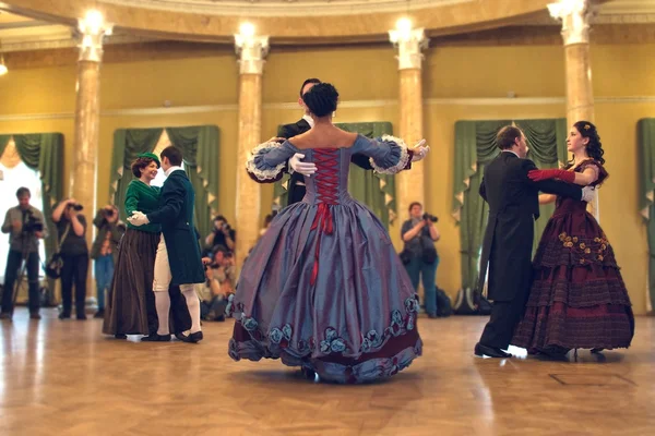 Pareja en vestido histórico bailando un vals en el salón de baile — Foto de Stock