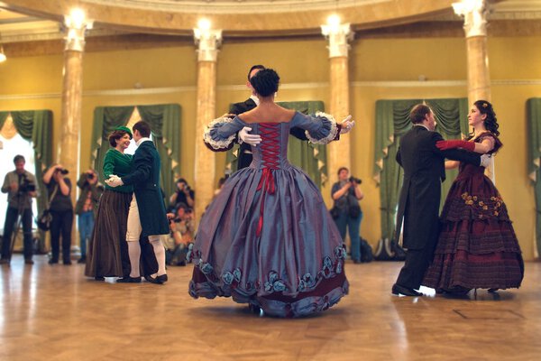 Pair in historical dress dancing a waltz in the ballroom