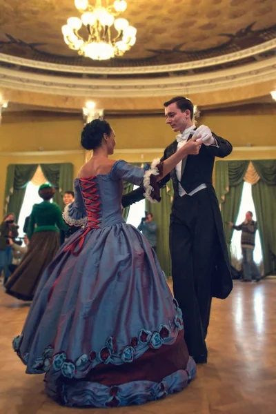 Pareja en vestido histórico bailando un vals en el salón de baile — Foto de Stock