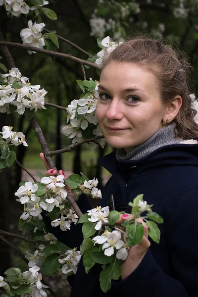 The girl among white flowers in apple orchard — Stock Photo, Image