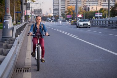 Şehirde bisiklet süren bir kadın.