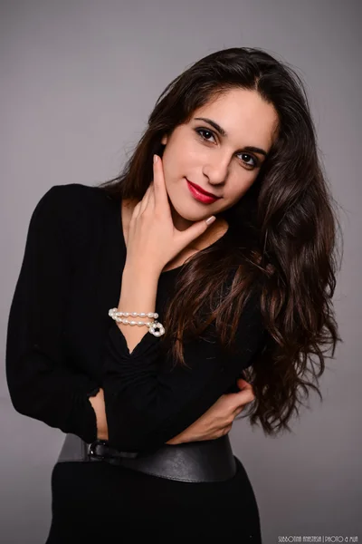 Young girl with long dark hair in a dark dress — Stock Photo, Image