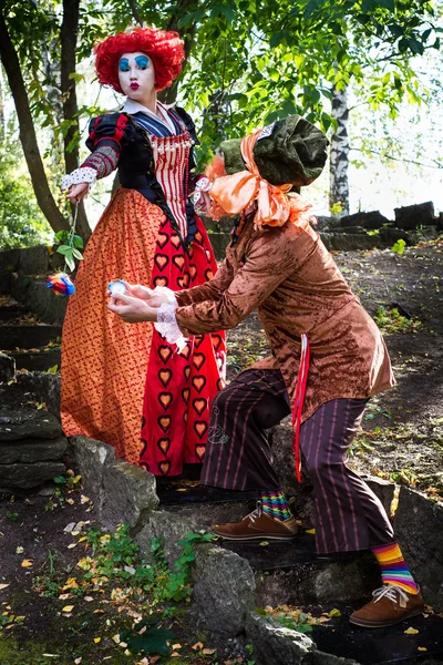 Jovem mulher e homem à imagem do Chapeleiro e da Rainha Vermelha do conto de fadas sobre Alice — Fotografia de Stock