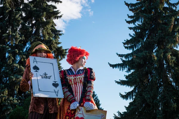 Jovem mulher e homem à imagem do Chapeleiro e da Rainha Vermelha do conto de fadas sobre Alice — Fotografia de Stock