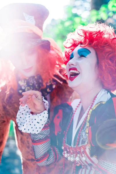 Jovem mulher e homem à imagem do Chapeleiro e da Rainha Vermelha do conto de fadas sobre Alice rindo juntos — Fotografia de Stock