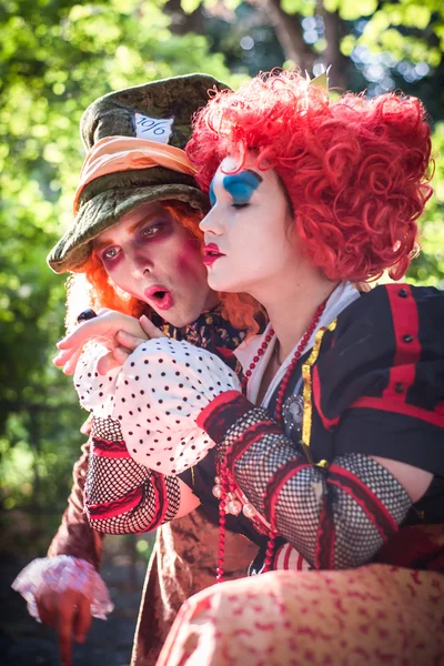 Jovem mulher e homem à imagem do Chapeleiro e da Rainha Vermelha do conto de fadas sobre Alice rindo juntos — Fotografia de Stock