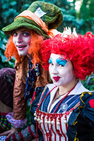 Jovem mulher e homem à imagem do Chapeleiro e da Rainha Vermelha do conto de fadas sobre Alice — Fotografia de Stock