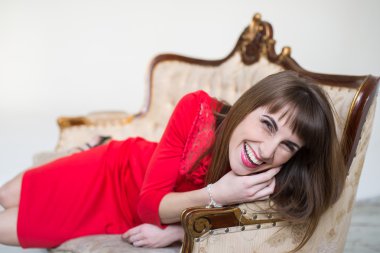 Genç kadın parlak makyaj güzel bir kanepede poz ile ince yapılı