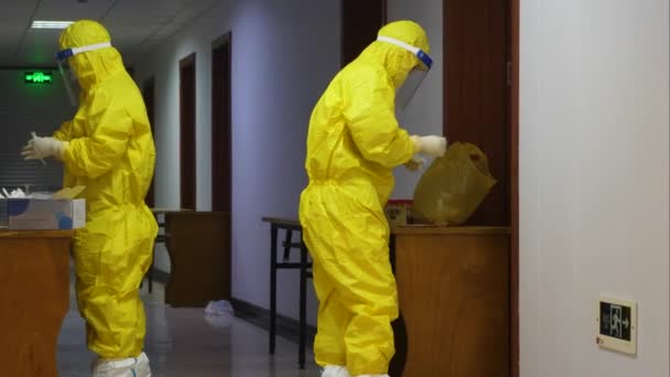 COVID-19 Période.Les voyageurs internationaux mis en quarantaine pendant 14 jours en Chine.Les travailleurs médicaux portant des vêtements de protection prélèvent des échantillons d'écouvillonnage de la gorge à l'hôtel où vit le personnel de l'immigration — Video