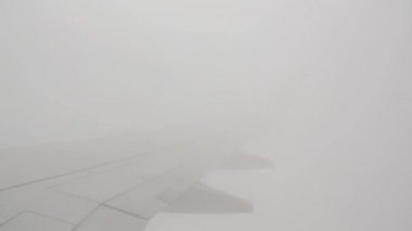 Sivil bir uçakla seyahat ederken, pencerenin dışındaki kanat gökyüzünde, mavi gökyüzü ve beyaz bulutlar 10.000 metre yükseklikte.