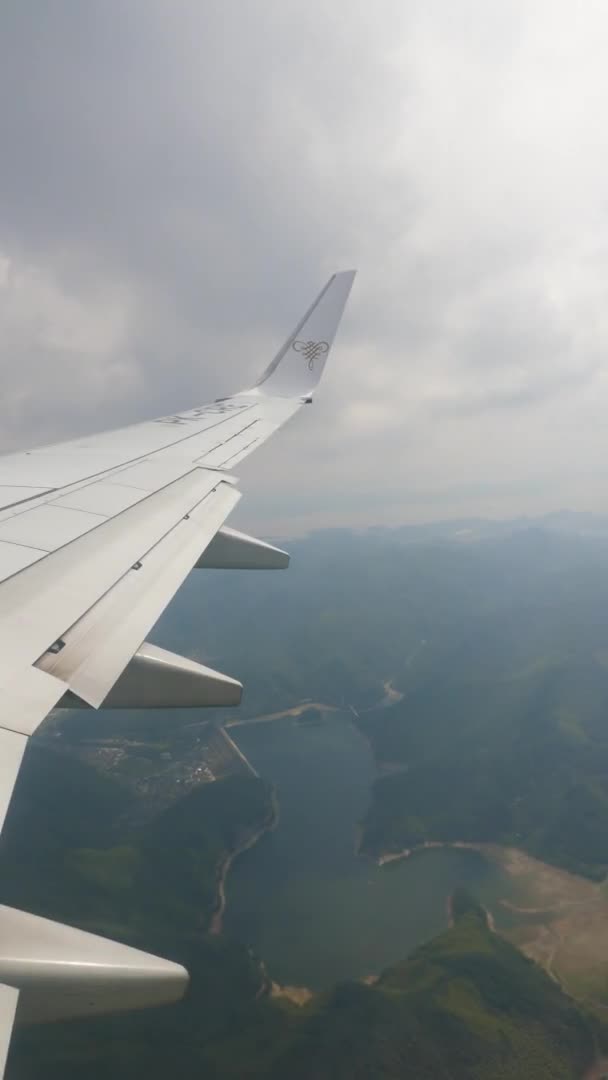 VERTICAL FOOTAGE, тяжіння на цивільному авіалайнері, крило за межами отвору знаходиться в блакитному небі і білих хмарах на висоті 10 000 метрів — стокове відео