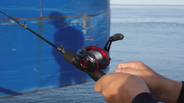 Un homme pêche sur la côte.Préparer l'équipement de pêche avant la pêche, attacher la ligne de pêche et accrocher l'appât — Video