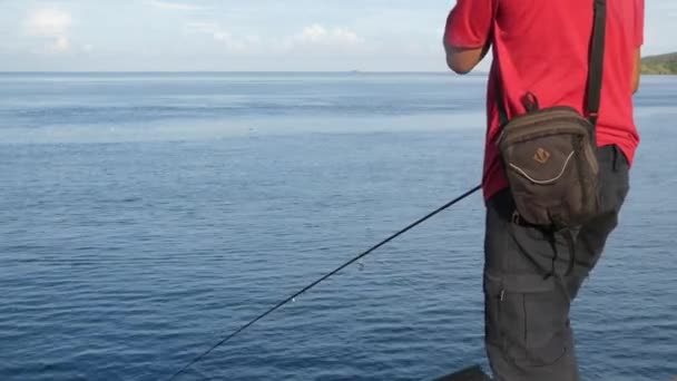 Um homem pescando na costa — Vídeo de Stock